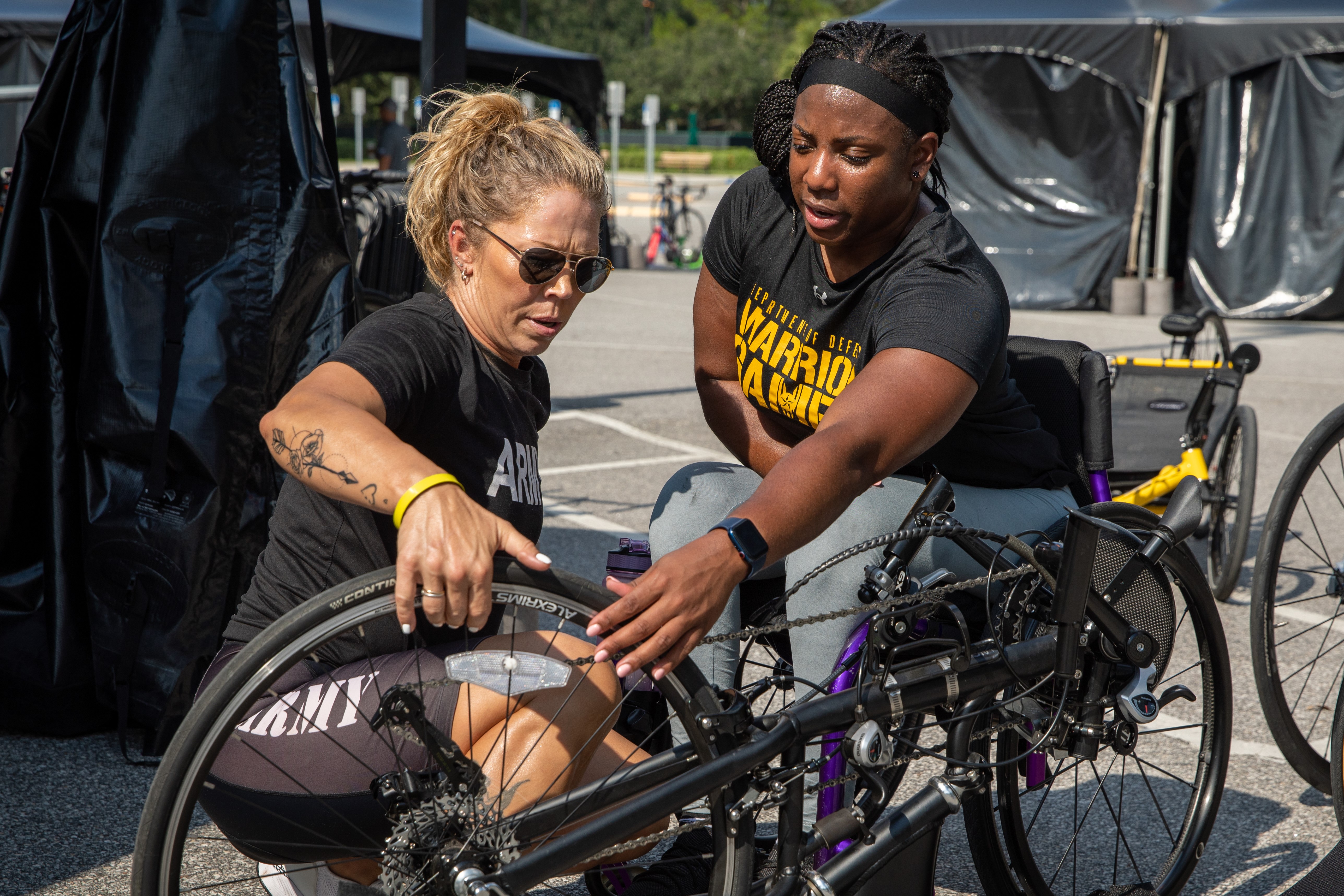 Participants working on wheelchair before track event.